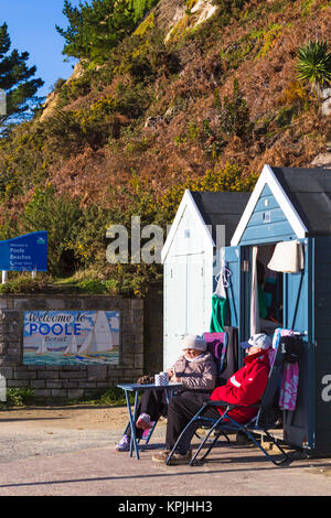 Bournemouth, Dorset, Großbritannien. 16. Dezember, 2017. UK Wetter: Kalt, aber sonnigen Tag am Meer bei Alum Chine, als Paar genießen Sie den Sonnenschein draußen sitzen Beach Hut warm eingepackt und in eine heiße Tasse Tee. Credit: Carolyn Jenkins/Alamy leben Nachrichten Stockfoto