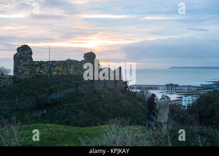 Hastings, East Sussex, UK. 16 Dec 2017, nach einem sonnigen Tag, Besucher beobachten Sie den Sonnenuntergang vom Castle Hill, aber bei Regen Wolken aus dem Westen. Stockfoto