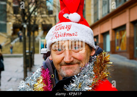 Glasgow, Schottland, Großbritannien. 16. Dezember, 2017. Wie tausende von Käufer zu Glasgow City Centre beflockt und insbesondere der Buchanan Street auch bekannt als Glasgow's Stil Meile viele in die saisonale Geist eingegeben und genossen das Unterhaltungsprogramm von der Straße Musiker und Gaukler. Bild ist von PAUL KELLY, die heimatlos wurde und den Verkauf der grosse Ausgabe für 5 Monate Quelle: Findlay/Alamy leben Nachrichten Stockfoto