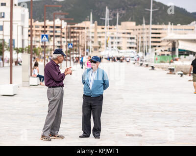 IBIZA, SPANIEN - 24. MAI 2015. Zwei alte Männer reden und laufen in den Hafen in Ibiza. Stockfoto