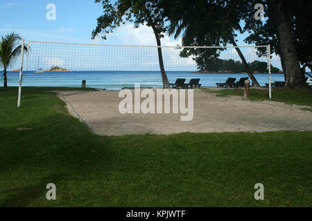 Sand-Volleyballplatz entlang Rasen Paradise Sun Hotel in der Nähe von Strand, Insel Praslin, Seychellen. Stockfoto