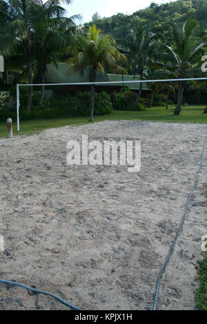 Sand-Volleyballplatz entlang Rasen Paradise Sun Hotel in der Nähe von Strand, Insel Praslin, Seychellen. Stockfoto