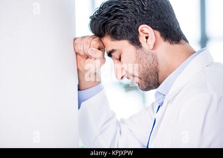 Junge männliche Student der Medizin mit Kopf in den Händen. Stockfoto