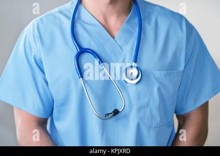 Männlicher Arzt in blauer Uniform mit Stethoskop. Stockfoto