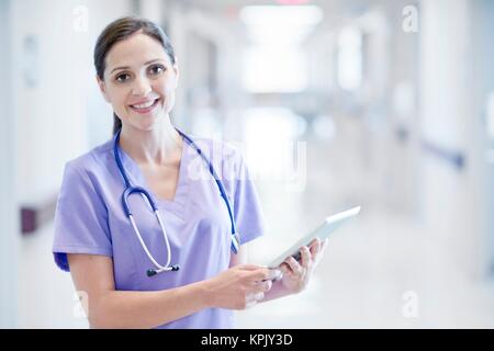 Krankenschwester trägt Lila einheitliche mit digitalen Tablet. Stockfoto
