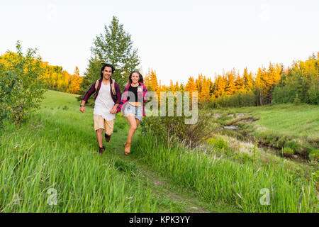 Junges Paar Hände halten und zusammen ein Trail in einer Stadt Park; Edmonton, Alberta, Kanada Stockfoto