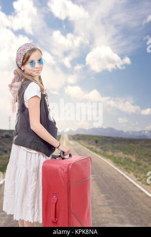 junges Mädchen mit Vintage-Kleidung und Koffer unterwegs Stockfoto