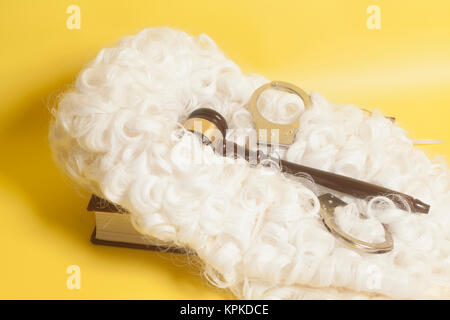 Für Richter: Richter Perücke, handclufs, Richter Hammer, Buch auf gelbem Hintergrund Stockfoto