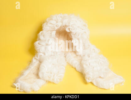 Perücke auf gelbem Hintergrund beurteilen. Stockfoto