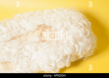 Perücke auf gelbem Hintergrund beurteilen. Stockfoto
