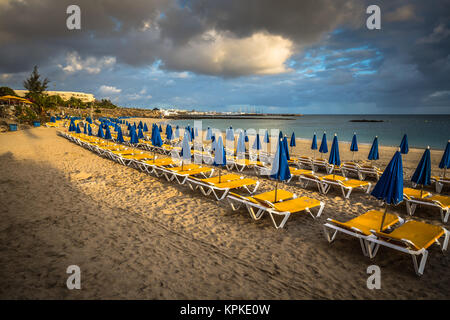 Schöne Liegestühle und Sonnenschirme am Strand Stockfoto