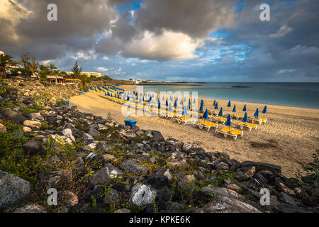 Schöne Liegestühle und Sonnenschirme am Strand Stockfoto