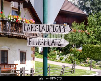 Anzeichen für die Langlaufloipe und der örtlichen Flugplatz im Bergdorf Mauterndorf in den österreichischen Alpen. Stockfoto