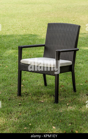 Rattan Stuhl mit Kissen im Garten Stockfoto