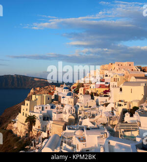 Das Dorf Oia auf Santorini in Griechenland, am frühen Morgen, die ersten Strahlen der aufgehenden Sonne Panoramic Image beleuchtet Stockfoto