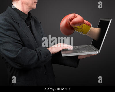 Mann im schwarzen Hemd und Anzug mit einem Laptop Stockfoto