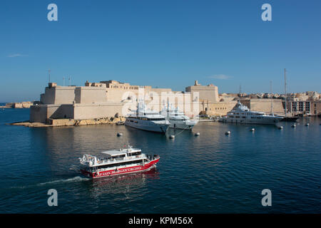 Grand Harbour Tour Boot vorbei an Fort St. Angelo, Malta, mit Touristen Sightseeing an Bord. Der Tourismus ist ein wichtiger Wirtschaftssektor in Malta. Stockfoto