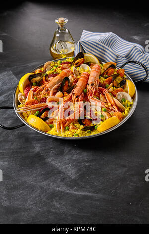 Gourmet Meeresfrüchte Paella mit Langusten, Muscheln und Tintenfische oder Octopus garniert mit frischem Zitronensaft, dazu ein Olivenöl Dressing, Vordergrund Platz kopieren Stockfoto