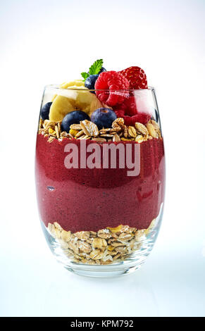 Hohes Glas voller gemischt Acai, Banane, Blaubeere und Haferflocken auf weißem Hintergrund mit Schatten Stockfoto