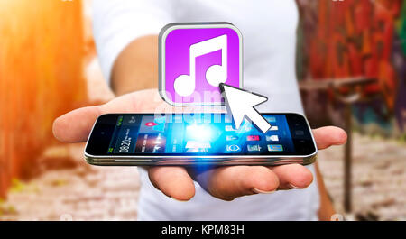 Junger Mann mit modernen Mobiltelefon Musik hören Stockfoto