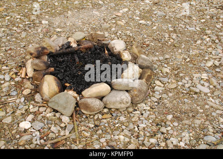 Feuerstelle am Flussufer Stockfoto