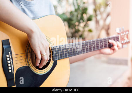 Die Frau Hände spielen akustische Gitarre Stockfoto