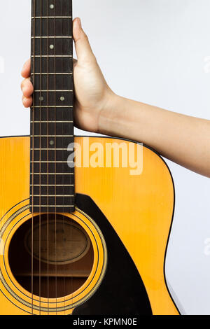 Woman's Hand, die Akustische Gitarre auf weißem Hintergrund Stockfoto