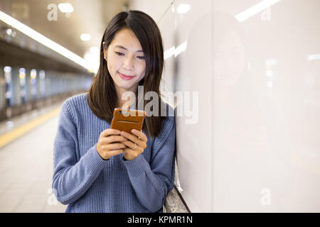 Frau mit Handy in der U-Bahn Stockfoto