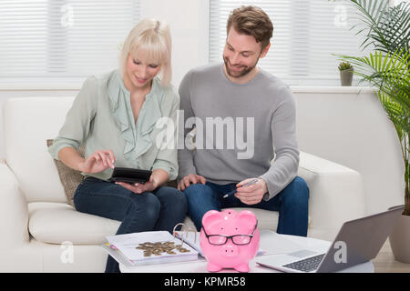 Paar Berechnung Münze in das Sparschwein Stockfoto