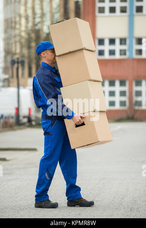 Delivery Man Balancing Stapel von Kisten Stockfoto