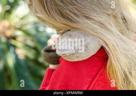 Kleines Mädchen umarmt den sehr alten abgenutzten Teddy fest Stockfoto