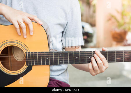 Die Frau Hände spielen akustische Gitarre Stockfoto