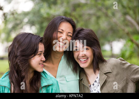 Asiatische Mutter Lachen und huging ihre Kinder. Stockfoto