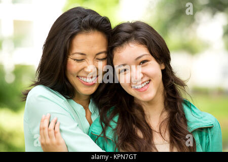 Asiatische Mutter Lachen und huging Ihr Kind. Stockfoto