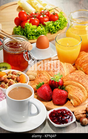 Das Frühstück besteht aus Croissants, Kaffee, Obst, Orangensaft Stockfoto