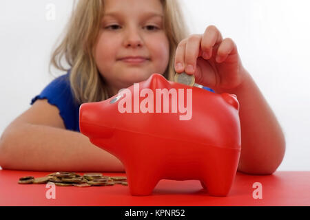 Model Release, näher, 8 Jahre, Fuettert Sparschwein - Mädchen mit Sparschwein Stockfoto