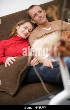 Model Release, Liebespaar Sitzt Gemeinsam Auf der Couch - Liebespaar sitzt auf einer Couch zu Hause Stockfoto