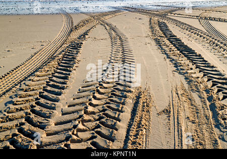 Eine Ansicht von Traktor und Anhänger Reifenspuren im Sand am Strand am Meer Palling, Norfolk, England, Vereinigtes Königreich. Stockfoto