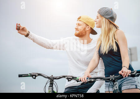 Glückliches Paar mit Fahrrad unter selfie im Freien Stockfoto