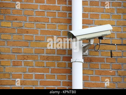 Überwachung Kamera montiert auf Yellow Brick Wall Stockfoto