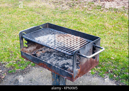 Dreckige rostige Grill in der Nähe von Gras. Stockfoto