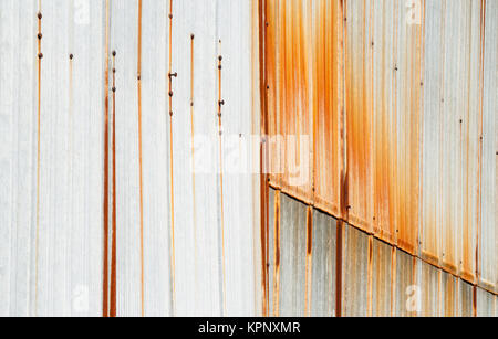 Metal siding mit vertikalen Rostflecken. Stockfoto