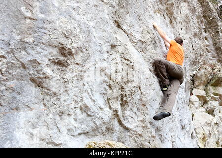 Person klettert auf natürliche Felswand Stockfoto