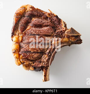 Gegrillte marinierte Cote de Boeuf, oder Knochen ribeye Steak mit Fett in einer Nahaufnahme, Ansicht von oben auf weißem beringt Stockfoto