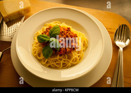 Top-Schuss Spaghetti Bolognese mit Basilikum in einem weißen Gericht Stockfoto