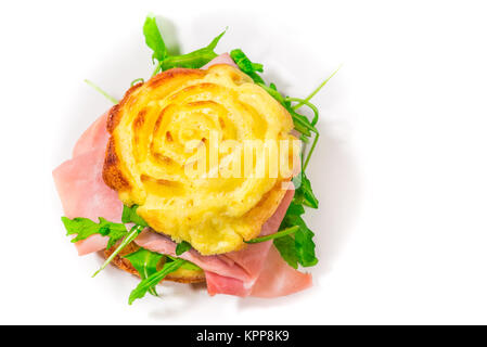 Gefüllte frittata, in der Mikrowelle gekocht, geformt wie eine Rose, mit Rucola und gekochten Schinken (Zutaten: Eier, Sahne, Salz, Emmentaler) Stockfoto