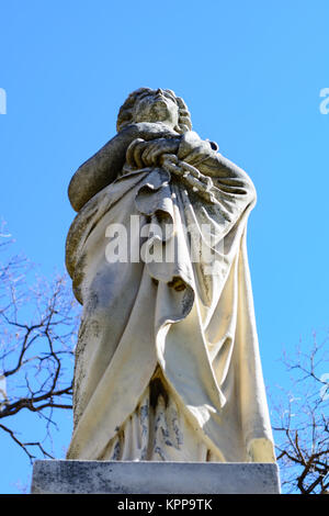 Haunting Statue einer Dame oder Engel in einem weißen Gewand steht, als ob über die Bewachung und beobachten. Stockfoto