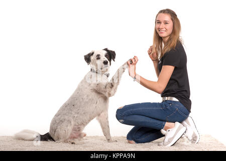 Das junge Mädchen gibt ihrem Hund Anweisungen, Pfote zu geben Stockfoto