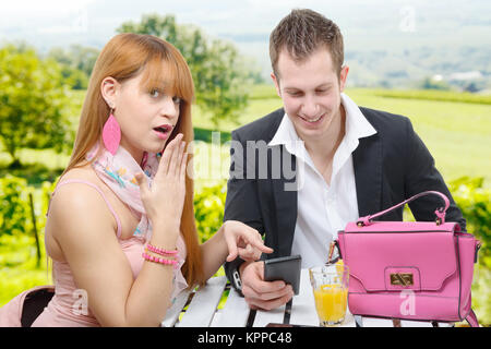 Junges Paar mit einem Smartphone in einem Café Terrasse Stockfoto