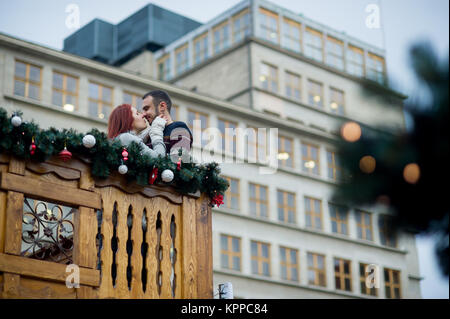 Kurz vor Weihnachten. Junges Paar auf dem Balkon aus Holz dekoriert von einem Urlaub. Romantische Verabredung. Stockfoto